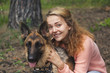 Young woman playing with German shepherd