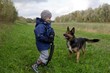 Kind spielt mit deutschem Schäferhund